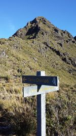 Information sign on field against clear sky