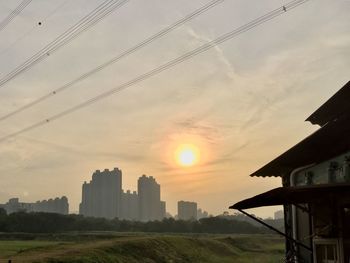 Buildings in city against sky during sunset