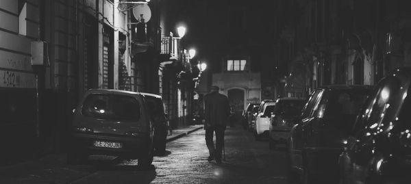 Rear view of man on illuminated street at night