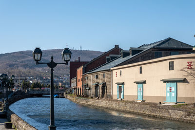 Street by buildings against clear blue sky