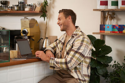 Side view of young man working at home