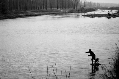 High angle view of silhouette man fishing in lake