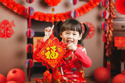 Girl holding lantern sitting at home