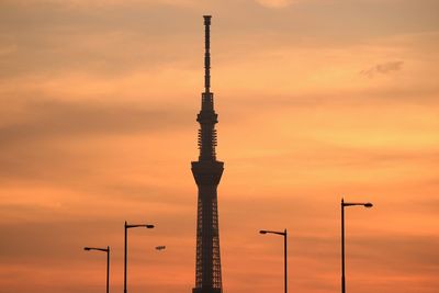 Low angle view of communications tower against sky at sunset