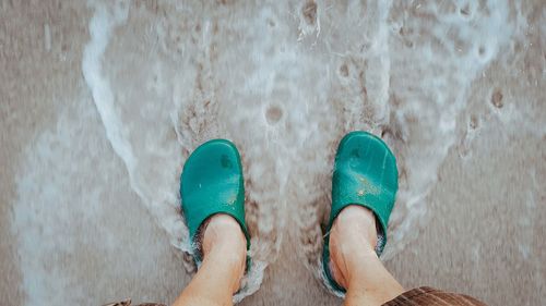 Low section of man standing on beach