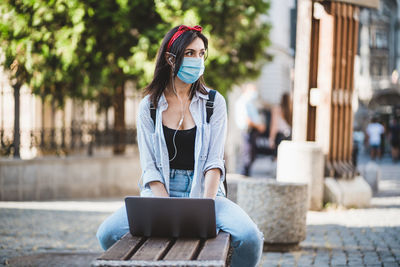 Young woman using mobile phone in city