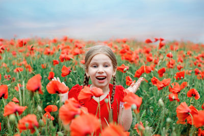 Portrait of beautiful young woman with flowers in field