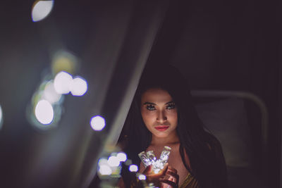 Portrait of young woman sitting outdoors