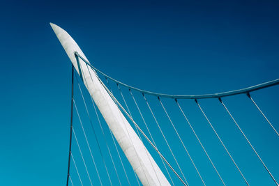 Low angle view of suspension bridge against clear blue sky