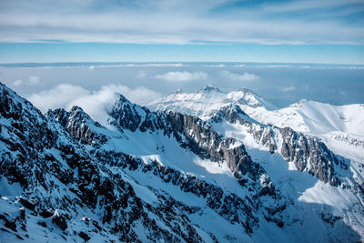 Scenic view of snowcapped mountains against cloudy sky