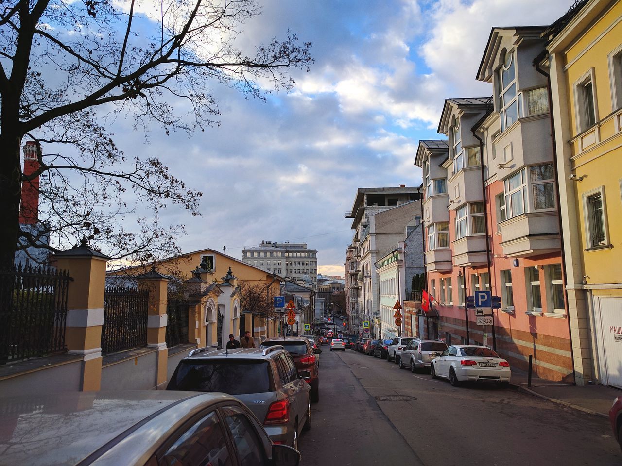 VEHICLES ON ROAD IN CITY AGAINST SKY