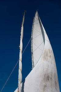 Low angle view of sailboat against clear blue sky