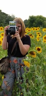 Midsection of woman photographing at camera
