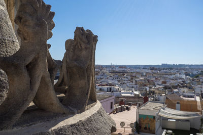 Statue in city against clear sky