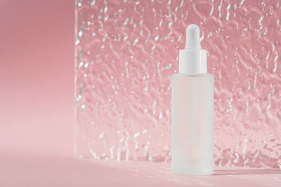 Hyaluronic acid oil mockup. anti aging serum with collagen and peptides on pink 