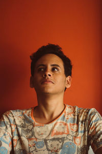 Close-up of young man against red background