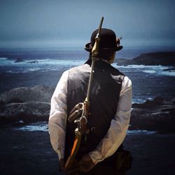 Man standing in sea against sky