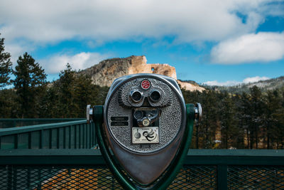 Close-up of coin-operated binoculars against sky