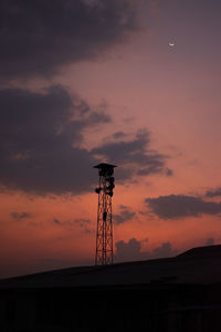 Silhouette electricity pylon against sky during sunset