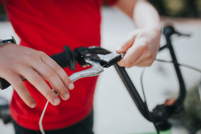 Midsection of boy holding bicycle handlebar