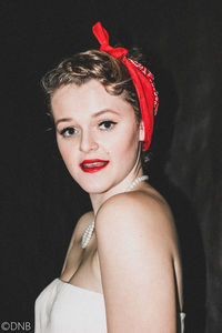 Portrait of woman with red hair against black background