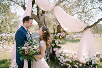 Low angle view of bride and bridegroom holding bouquet