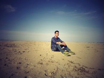 Portrait of young man on beach against sky