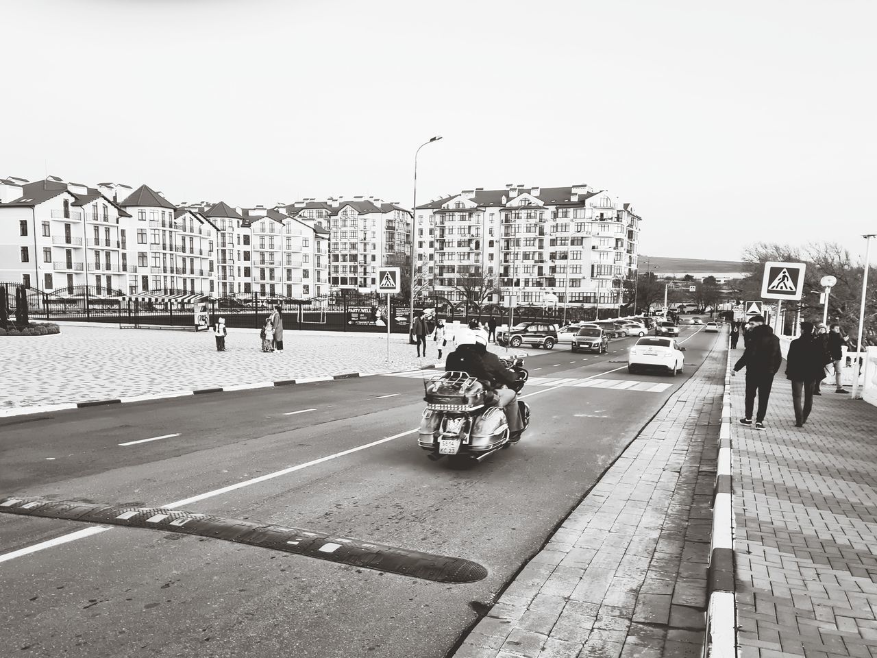 PEOPLE RIDING BICYCLES ON FOOTPATH BY BUILDINGS IN CITY