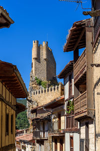 Low angle view of buildings against clear blue sky