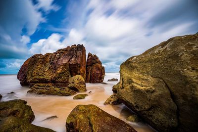 Rocks on beach against sky