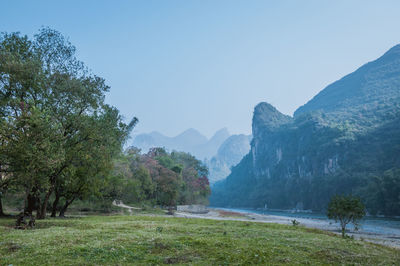 Scenic view of landscape and mountains against clear sky