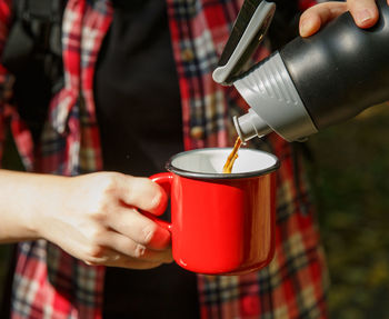 Midsection of woman holding coffee