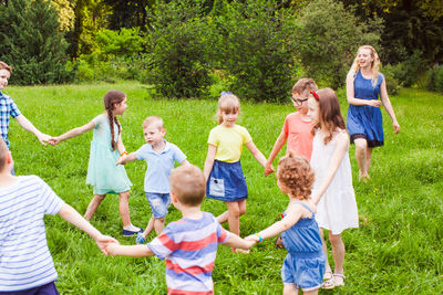 Rear view of people enjoying on grassland