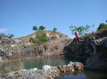 Rock formations in water against sky