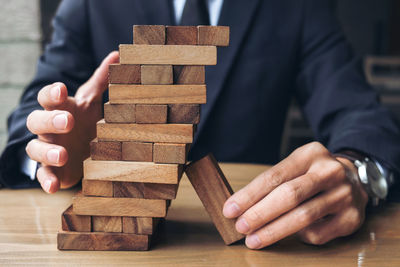 Midsection of businessman playing with dominoes at desk