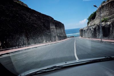 Empty road against cloudy sky