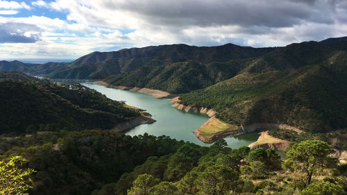 Scenic view of river amidst mountains against sky