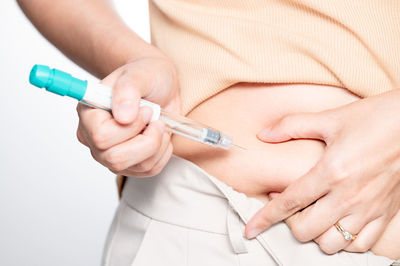 Midsection of doctor holding syringe