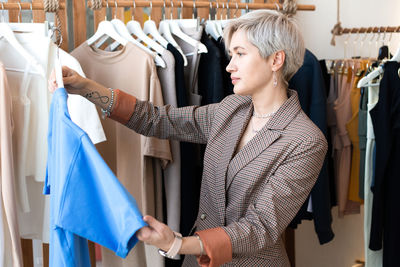 Woman choosing dress at store