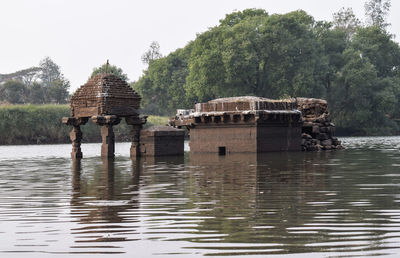 Built structure by lake against clear sky