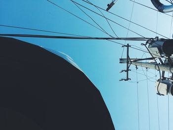 Low angle view of power lines against clear blue sky