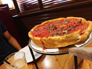 Midsection of person holding pizza with ice cream