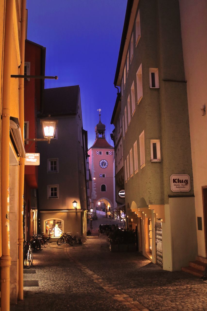 STREET AMIDST BUILDINGS IN CITY AT NIGHT