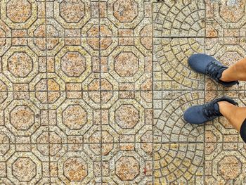 Low section of man standing on tiled floor