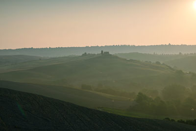 Scenic view of agricultural field against sky during sunset