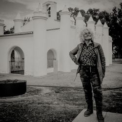 Full length of senior man standing against historic building