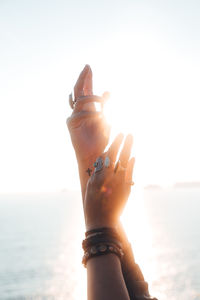 Cropped hands of woman against clear sky