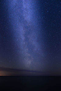 Scenic view of sea against star field at night