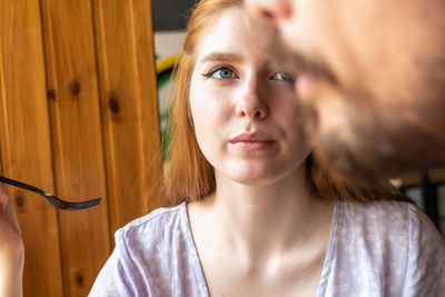 Portrait of young beautiful woman having dinner in little cafe and looking at her partner