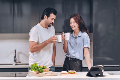 Happy young couple cheerful a coffee together during eating breakfast